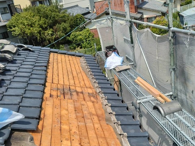 既存の瓦を取り外し、野地板が露出した瓦屋根の葺き直し作業の様子