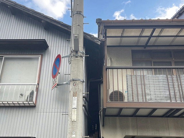 雨漏り調査の対象住宅の外壁と隣家の屋根が接している状況の地上からの様子