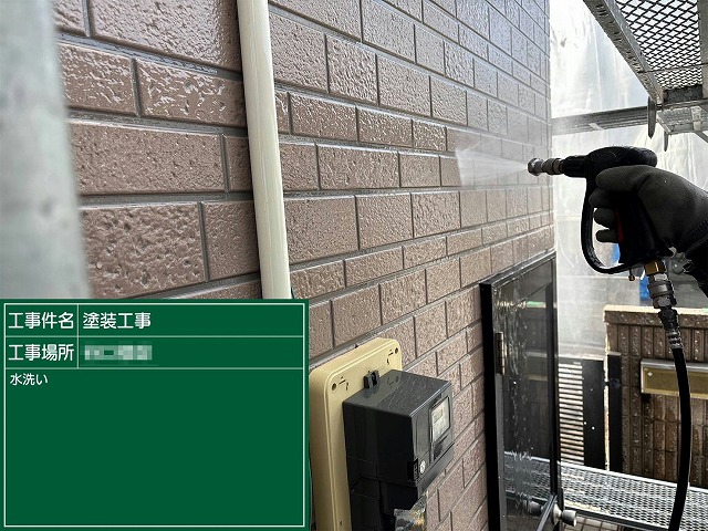 高圧洗浄でサイディング外壁の旧塗膜や汚れを洗い流している様子