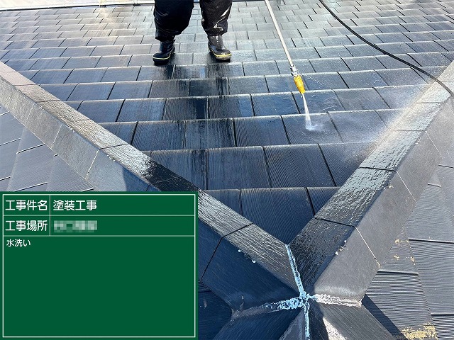 セメント瓦屋根の谷部分を高圧洗浄機で洗浄している作業員の様子