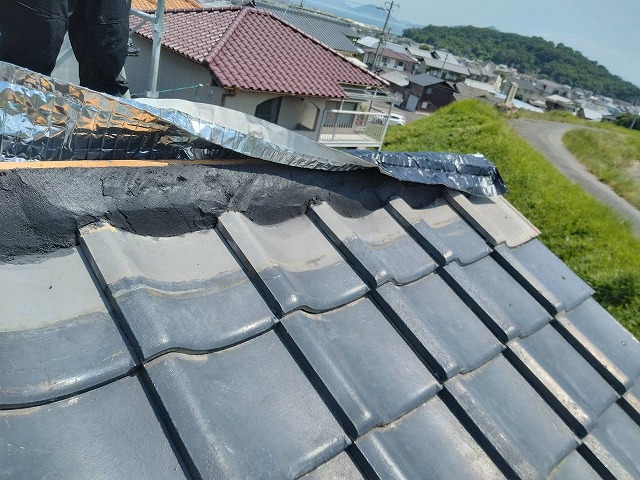 南蛮漆喰の土台に乾式面戸シートを被せていく棟部の施工状況