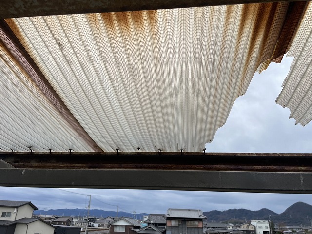 劣化の進行により一部が飛散した住宅ベランダのガラスネット入り塩ビ波板