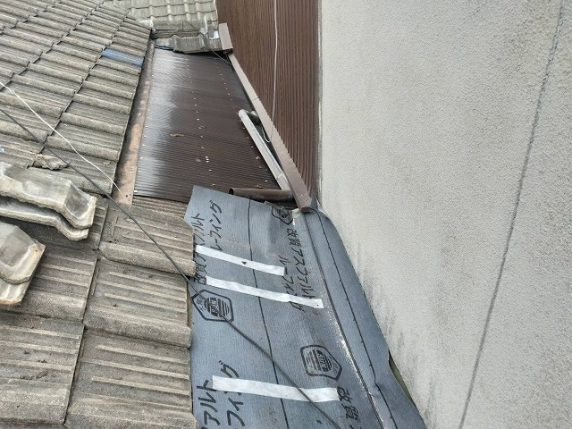 外壁と隣家の屋根との取り合い部で防水シートの敷設が完了した状態