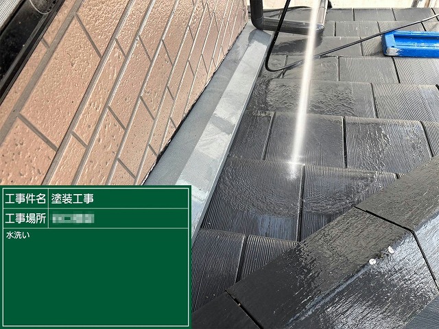 下屋根と外壁の取り合い部分を高圧洗浄している施工状況